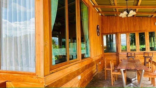 A long wooden dining hall with a chandelier and a slow afternoon light.