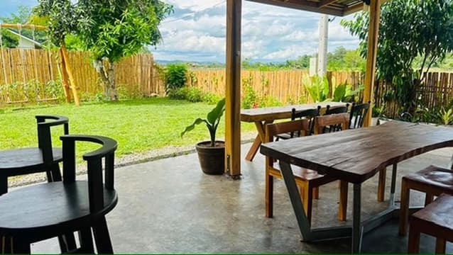 An outdoor dining table looking out across the field toward distant hills.